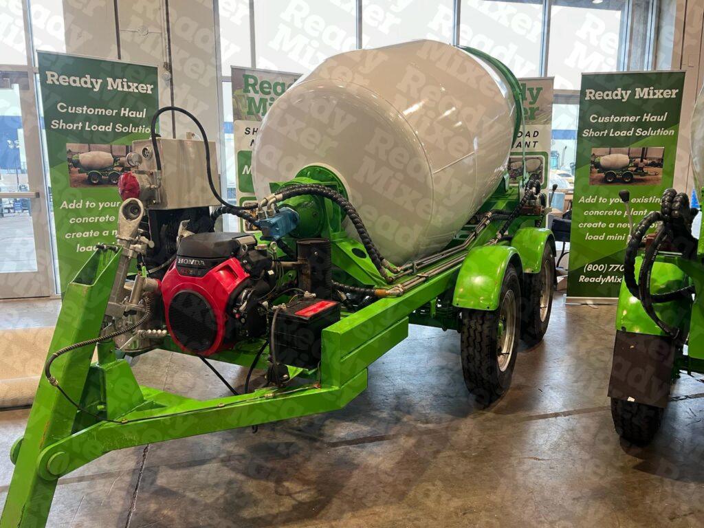 Ready Mixer display featuring trailer-mounted concrete mixers with white drums and green frames at World of Concrete expo