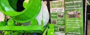 Ready Mixer display featuring green concrete mixer and promotional banners for short load mini plant solutions