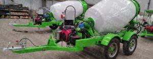 Line of 3-yard concrete mixers with white drums and green frames featuring Honda engines on tandem axle trailers