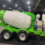 Ready Mixer portable concrete mixing trailer with large white drum on display at a trade show