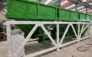 Green Ready Mixer multi-compartment aggregate hopper with white support frame and access ladder